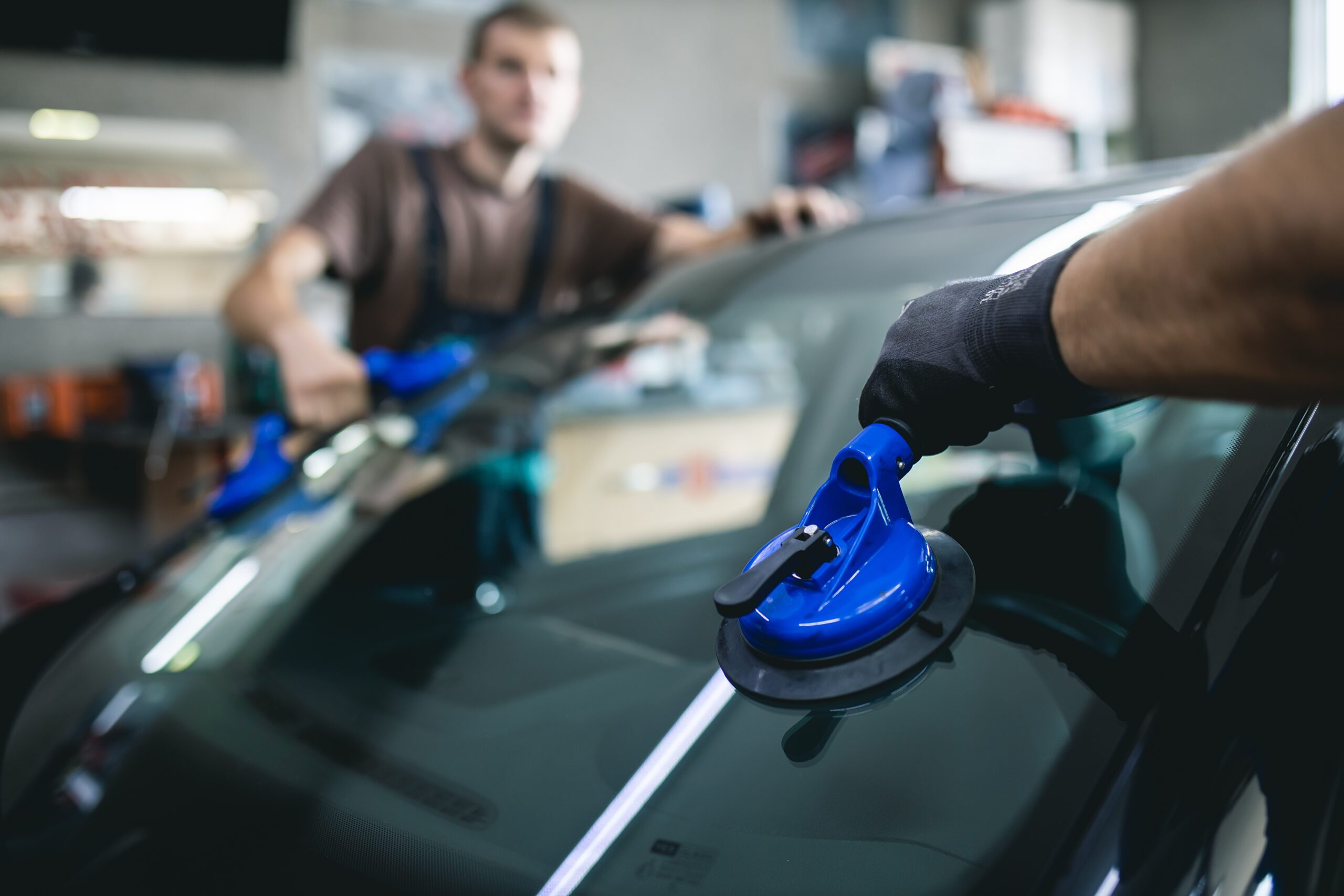 windshield replacement being done by two men