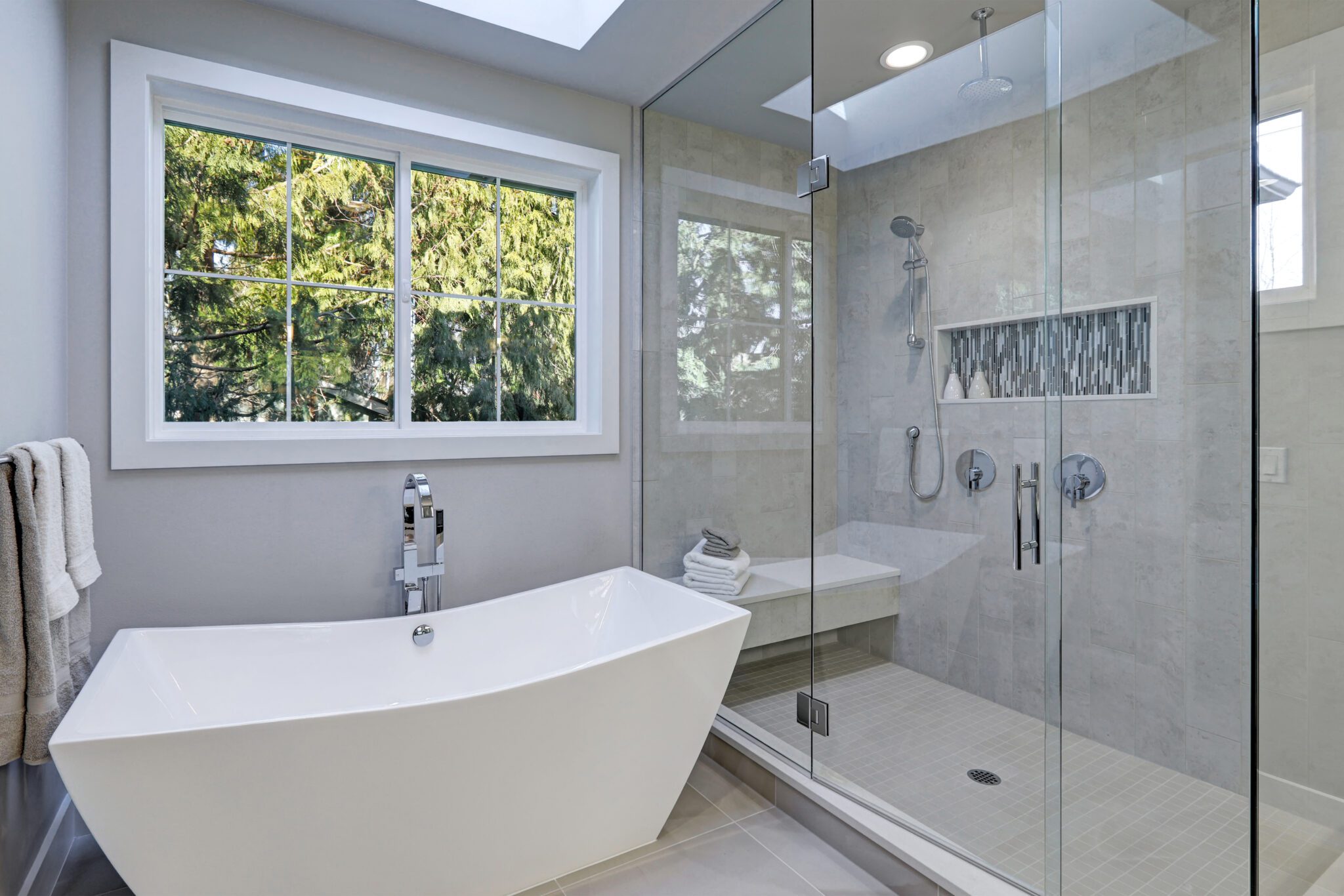 Bathroom with glass shower door with tile and angular tub